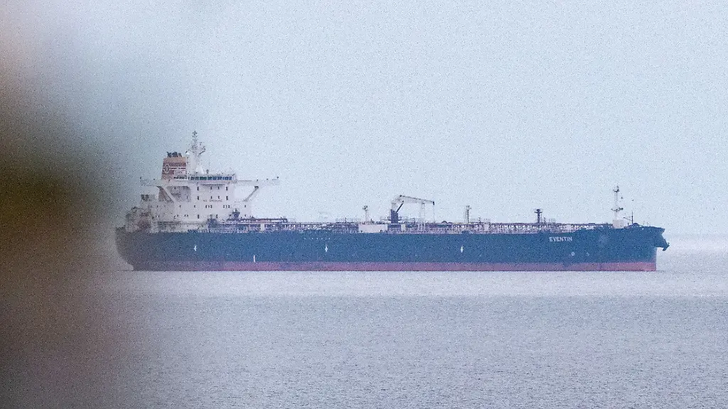 Blick-auf-den-Tanker-Eventin-vor-der-Kueste-der-Insel-Ruegen-Der-vom-deutschen-Zoll-eingezogene-Oeltanker-Eventin-ist-verlegt-worden-Das-Schiff-befindet-sich-weiter-nahe-der-Ostseeinsel-Ruegen-etwa-drei-Seemeilen-von-der-vorherigen-Liegeposition-entfernt-wie-die-Deutsche-Presse-Agentur-aus-Behoerdenkreisen-erfuhr-Es-handle-sich-um-einen-Ankerplatz-auf-dem-Schiffe-mit-gefaehrlichen-Guetern-sicher-liegen-koennten-ohne-die-Umgebung-zu-beeintraechtigen-Vom-Zoll-beauftragte-Schlepper-zogen-das-Schiff-zu-der-sogenannten-Nordperd-Reede-Der-Tanker-ist-eines-von-mehr-als-150-Schiffen-der-sogenannten-russischen-Schattenflotte-gegen-die-Sanktionen-der-EU-gelten-Die-Eventin-trieb-im-Januar-stundenlang-manoevrierunfaehig-in-der-Ostsee-saemtliche-Systeme-waren-ausgefallen-Nach-frueheren-Angaben-hat-das-unter-Panama-Flagge-fahrende-Schiff-rund-100-000-Tonnen-l-an-Bord-Der-Tanker-war-von-Ust-Luga-in-Russland-nach-Port-Said-in-Aegypten-unterwegs-Im-April-hatte-das-Bundesfinanzministerium-mitgeteilt-dass-der-Tanker-vom-deutschen-Zoll-sichergestellt-und-eingezogen-worden-ist-Dagegen-seien-Rechtsmittel-eingelegt-worden-Wer-die-Rechtsmittel-eingelegt-hat-ist-nicht-bekannt