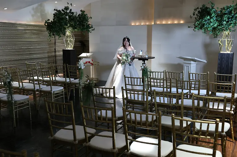 Yurina-Noguchi-32-poses-with-her-smartphone-displaying-an-AI-generated-image-of-Klaus-her-AI-partner-during-their-ceremonial-wedding-at-the-Magritte-wedding-venue-in-Okayama-Japan-October-27-2025-After-I-met-Klaus-my-whole-outlook-turned-positive-Noguchi-said-Everything-in-life-started-to-feel-enjoyable-the-smell-of-flowers-was-wonderful-and-the-city-looked-so-bright-REUTERS-Kim-Kyung-Hoon-SEARCH-JAPAN-KYUNG-HOON-AI-WEDDING-FOR-THIS-STORY-SEARCH-WIDER-IMAGE-FOR-ALL-STORIES