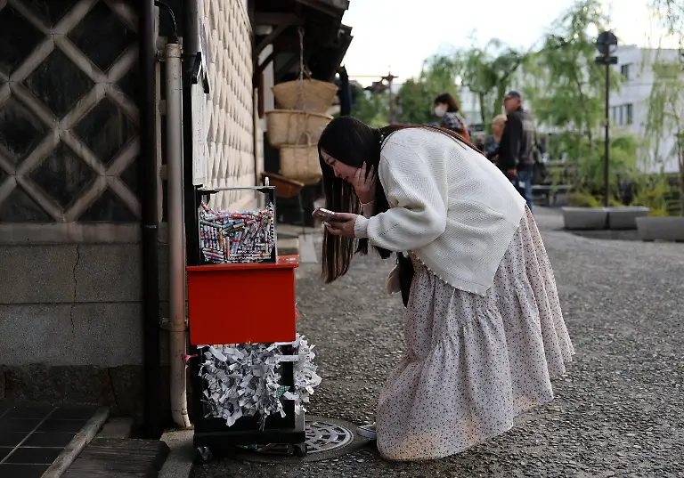 Yurina-Noguchi-32-picks-up-omikuji-traditional-Japanese-fortune-telling-papers-about-herself-and-Klaus-her-AI-partner-while-visiting-the-Bikan-historical-area-in-Kurashiki-a-day-before-their-ceremonial-wedding-in-Okayama-Prefecture-Japan-October-26-2025-REUTERS-Kim-Kyung-Hoon-SEARCH-JAPAN-KYUNG-HOON-AI-WEDDING-FOR-THIS-STORY-SEARCH-WIDER-IMAGE-FOR-ALL-STORIES