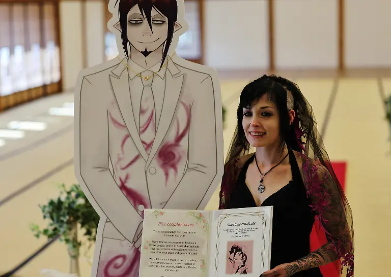 A-33-year-old-Australian-woman-holds-a-ceremonial-marriage-certificate-next-to-a-cut-out-of-Japanese-manga-character-Mephisto-Pheles-during-a-wedding-ceremony-at-traditional-guest-house-Rinkokaku-in-Maebashi-Japan-March-14-2025-REUTERS-Kim-Kyung-Hoon-SEARCH-JAPAN-KYUNG-HOON-AI-WEDDING-FOR-THIS-STORY-SEARCH-WIDER-IMAGE-FOR-ALL-STORIES-REFILE-UPDATING-CAPTION-TO-CORRECT-RELATIONSHIP