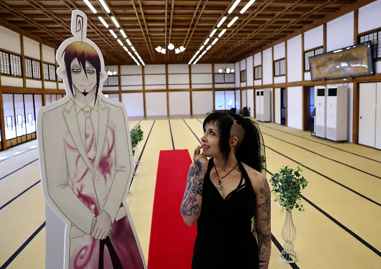 A-33-year-old-Australian-woman-looks-at-a-cut-out-of-Japanese-manga-character-Mephisto-Pheles-during-a-wedding-ceremony-at-traditional-guest-house-Rinkokaku-in-Maebashi-Japan-March-14-2025-REUTERS-Kim-Kyung-Hoon-SEARCH-JAPAN-KYUNG-HOON-AI-WEDDING-FOR-THIS-STORY-SEARCH-WIDER-IMAGE-FOR-ALL-STORIES-REFILE-UPDATING-CAPTION-TO-CORRECT-RELATIONSHIP