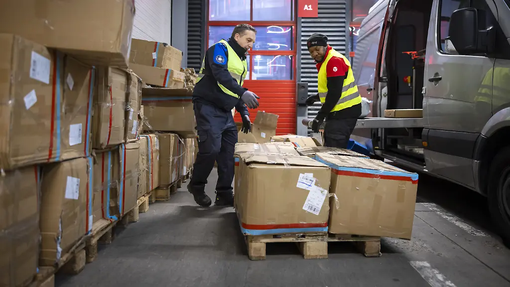 Ein-Mitarbeiter-des-Bundesamts-fuer-Zoll-und-Grenzsicherheit-BAZG-links-und-ein-Mitarbeiter-des-Logistikunternehmens-DPD-sortieren-Pakete-fuer-ein-mobiles-Roentgengeraet-waehrend-einer-Schwerpunktkontrolle-im-grenzueberschreitenden-Online-Handel-des-Bundesamts-fuer-Zoll-und-Grenzsicherheit-im-Paketverkehr-im-DPD-Paketzentrum-in-Buchs-ZH-am-Dienstag-12-November-2024-in-Buchs-ZH