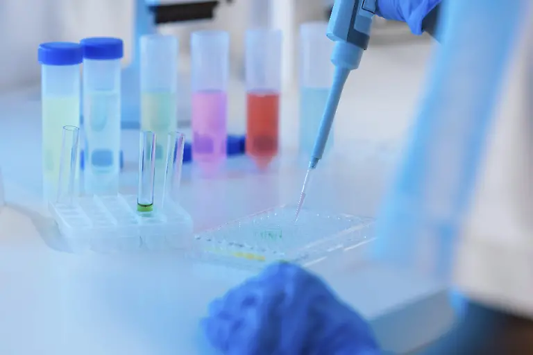 Laborwissenschaftler-verwendet-eine-praezise-digitale-Pipette-zur-Messung-des-Fluessigkeitsvolumens-in-Biologie-Chemie-oder-Medizin-und-tropft-Fluessigkeit-in-Reagenzglaeser