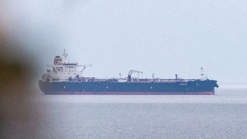 Blick-auf-den-Tanker-Eventin-vor-der-Kueste-der-Insel-Ruegen-Der-vom-deutschen-Zoll-eingezogene-Oeltanker-Eventin-ist-verlegt-worden-Das-Schiff-befindet-sich-weiter-nahe-der-Ostseeinsel-Ruegen-etwa-drei-Seemeilen-von-der-vorherigen-Liegeposition-entfernt-wie-die-Deutsche-Presse-Agentur-aus-Behoerdenkreisen-erfuhr-Es-handle-sich-um-einen-Ankerplatz-auf-dem-Schiffe-mit-gefaehrlichen-Guetern-sicher-liegen-koennten-ohne-die-Umgebung-zu-beeintraechtigen-Vom-Zoll-beauftragte-Schlepper-zogen-das-Schiff-zu-der-sogenannten-Nordperd-Reede-Der-Tanker-ist-eines-von-mehr-als-150-Schiffen-der-sogenannten-russischen-Schattenflotte-gegen-die-Sanktionen-der-EU-gelten-Die-Eventin-trieb-im-Januar-stundenlang-manoevrierunfaehig-in-der-Ostsee-saemtliche-Systeme-waren-ausgefallen-Nach-frueheren-Angaben-hat-das-unter-Panama-Flagge-fahrende-Schiff-rund-100-000-Tonnen-l-an-Bord-Der-Tanker-war-von-Ust-Luga-in-Russland-nach-Port-Said-in-Aegypten-unterwegs-Im-April-hatte-das-Bundesfinanzministerium-mitgeteilt-dass-der-Tanker-vom-deutschen-Zoll-sichergestellt-und-eingezogen-worden-ist-Dagegen-seien-Rechtsmittel-eingelegt-worden-Wer-die-Rechtsmittel-eingelegt-hat-ist-nicht-bekannt