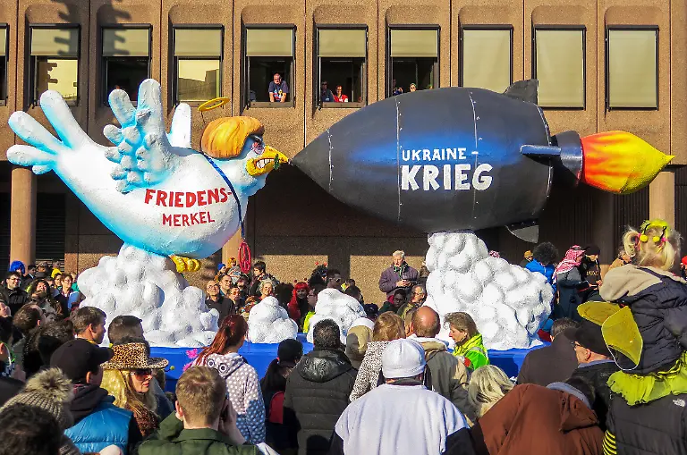 Angela-Merkel-als-Figur-auf-einem-Motivwagen-beim-Rosenmontagszug-2015-in-Duesseldorf-Dargestellt-als-Friedenstaube-mit-Heiligenschein-im-Zusammenhang-mit-dem-Ukraine-Krieg