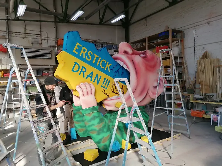 Ein-Mitarbeiter-des-Duesseldorfer-Wagenbaukuenstlers-Jacques-Tilly-legt-letzte-Hand-an-einen-Karikatur-Wagen-zum-Ukraine-Krieg-an-Tilly-will-den-Wagen-am-Rosenmontag-durch-Duesseldorf-rollen-lassen-Der-offizielle-Karnevalsumzug-wurde-schon-vor-Wochen-wegen-der-Coronapandemie-abgesagt