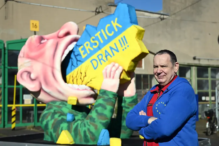 Jacques-Tilly-Wagenbauer-steht-vor-einem-Motivwagen-mit-dem-russischen-Praesidenten-Putin-der-die-Ukraine-schluckt-Wagenbauer-Jacques-Tilly-will-am-heutigen-Rosenmontag-einen-eigens-angefertigten-Karnevalswagen-zum-Ukraine-Krieg-durch-die-Stadt-rollen-lassen