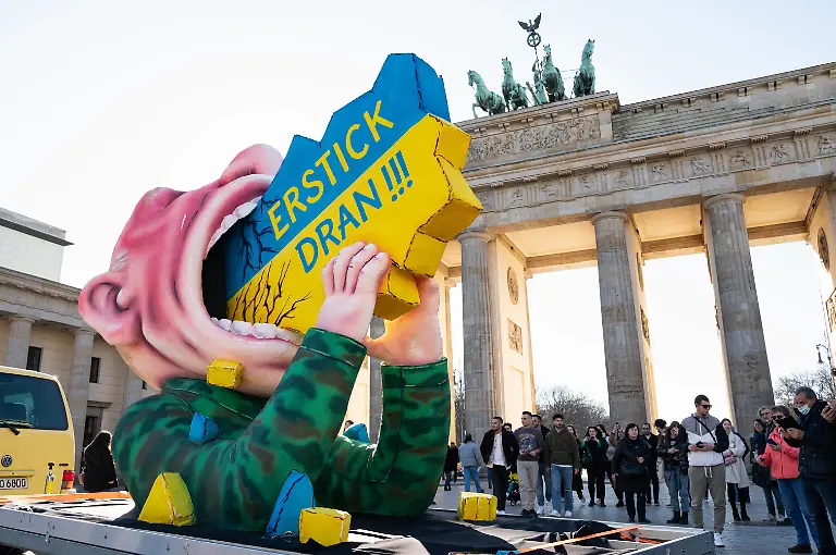 12-03-2022-Berlin-Deutschland-Europa-Ein-Karnevalswagen-des-Bildhauers-und-Wagenbauers-Jacques-Tilly-zeigt-auf-dem-Pariser-Platz-vor-dem-Brandenburger-Tor-einen-Wladimir-Putin-aus-Pappmache-mit-der-Aufschrift-Erstick-Dran-der-die-Ukraine-zu-verschlingen-versucht-als-symbolischen-Protest-gegen-die-russische-Invasion-und-den-Krieg-Putins