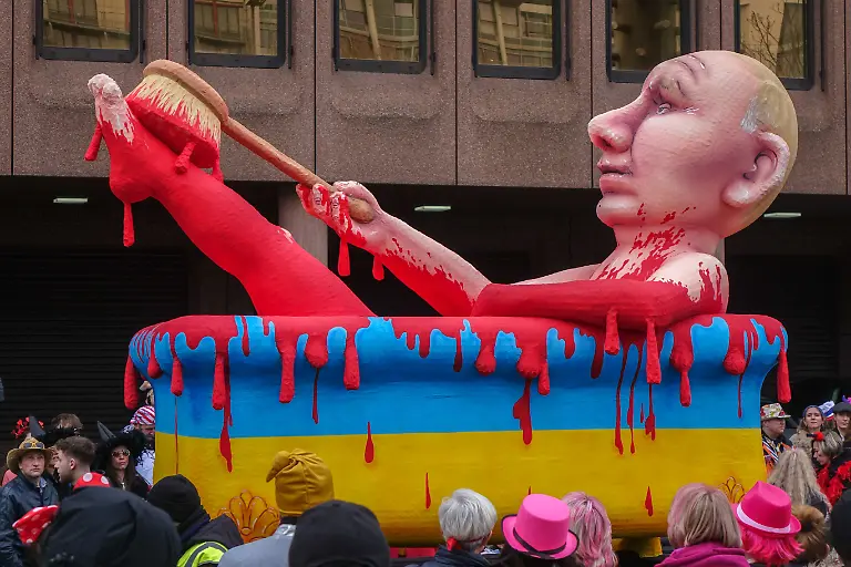 Mottowagen-von-Jacques-Tilly-beim-Rosenmontagszug-2023-in-Duesseldorf-Wladimir-Putin-waescht-sich-mit-Blut-in-einer-in-den-Farben-der-UKraine-bemalten-Badewanne