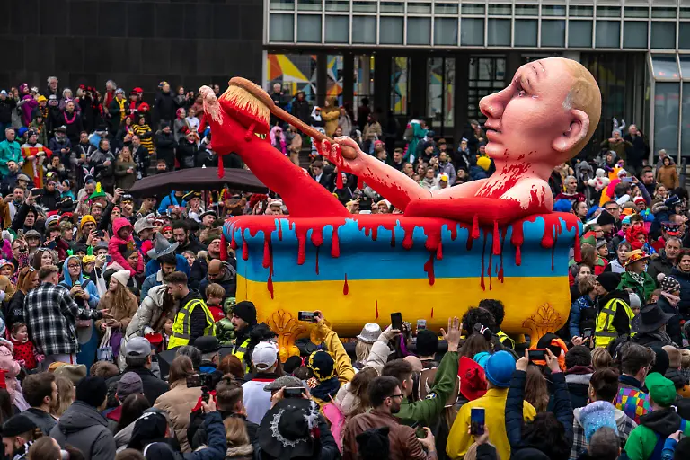 Rosenmontagszug-in-Duesseldorf-Strassenkarneval-Motivwagen-im-Karneval-von-Wagenbauer-Jacques-Tilly-Vladimir-Putin-badet-in-einer-Badewanne-in-den-Farben-der-Ukraine-voller-Blut