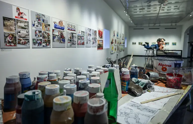 Figuren-und-Arbeitsmaterialien-stehen-in-der-Sonderausstellung-Jacques-Tilly-Freigeist-im-Stadtmuseum-Gezeigt-werden-in-der-Ausstellung-die-Entwuerfe-der-beruehmten-Mottowagen-der-Rosenmontagsumzuege-aus-ueber-vier-Jahrzehnten-Schaffenszeit-und-ebenso-Bilder-und-Arbeiten-aus-der-Jugendzeit-des-Kuenstlers