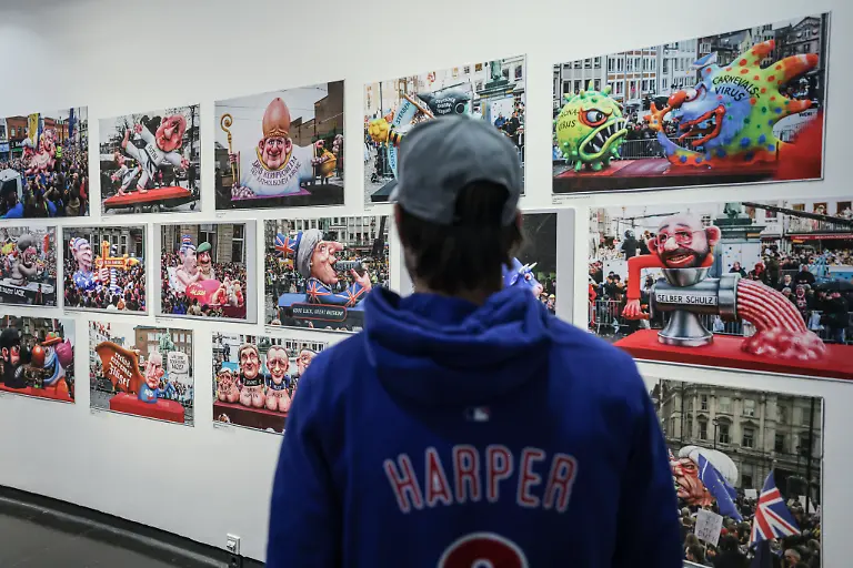 Ein-Besucher-steht-in-der-Sonderausstellung-Jacques-Tilly-Freigeist-im-Stadtmuseum-vor-Bildern-der-Motivwagen-vergangener-Jahre-Gezeigt-werden-in-der-Ausstellung-die-Entwuerfe-der-beruehmten-Mottowagen-der-Rosenmontagsumzuege-aus-ueber-vier-Jahrzehnten-Schaffenszeit-und-ebenso-Bilder-und-Arbeiten-aus-der-Jugendzeit-des-Kuenstlers