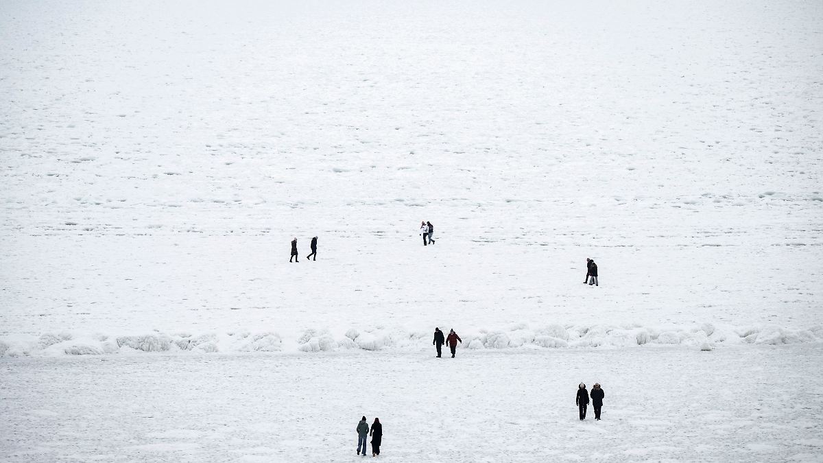 Menschen wandern auf zugefrorener Ostsee - Polizei warnt