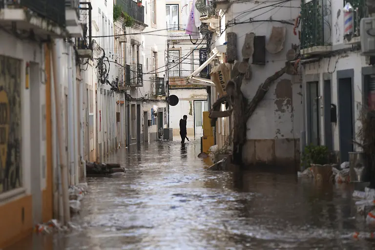 Ein-Anwohner-geht-eine-ueberflutete-Strasse-entlang-nachdem-der-Fluss-Sado-nach-heftigen-Regenfaellen-in-Alcacer-do-Sal-Suedportugal-ueber-die-Ufer-getreten-ist