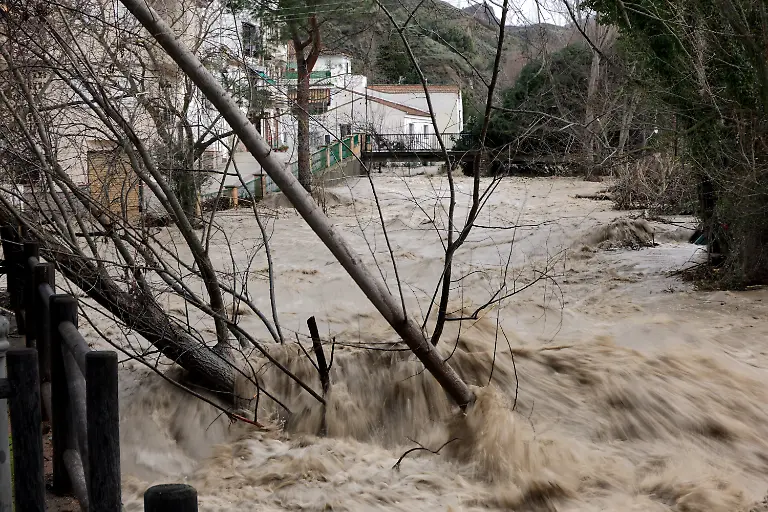 The-Aguas-Blancas-river-flows-through-the-village-of-Dudar-southern-Spain-on-February-5-2025-amid-Storm-Leonardo-Spain-today-lifted-its-highest-weather-alert-for-torrential-rain-in-the-southern-region-of-Andalusia-where-a-woman-went-missing-a-day-after-the-storm-killed-one-in-Portugal-Storm-Leonardo-dumped-more-than-40-centimetres-15-inches-of-rain-in-some-Andalusian-districts-yesterday-forcing-the-evacuation-of-thousands-paralysing-rail-and-road-transport-and-shutting-schools-The-downpours-which-came-after-a-storm-killed-five-people-and-left-hundreds-injured-in-neighbouring-Portugal-last-week-are-examples-of-extreme-weather-that-scientists-say-climate-change-is-worsening
