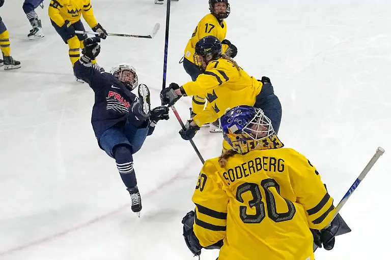 France-s-Clara-Rozier-left-falls-during-a-preliminary-round-match-of-women-s-ice-hockey-between-France-and-Sweden-at-the-2026-Winter-Olympics-in-Milan-Italy-Sunday-Feb-8-2026