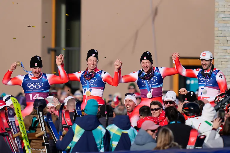 Olympia-Olympische-Winterspiele-Mailand-Cortina-2026-Ski-alpin-Team-Maenner-Slalom-die-Olympiasieger-Franjo-von-Allmen-l-r-und-Tanguy-Nef-beide-Schweiz-feiern-mit-den-Drittplatzierten-Marco-Odermatt-und-Loic-Meillard-beide-Schweiz-im-Zielbereich