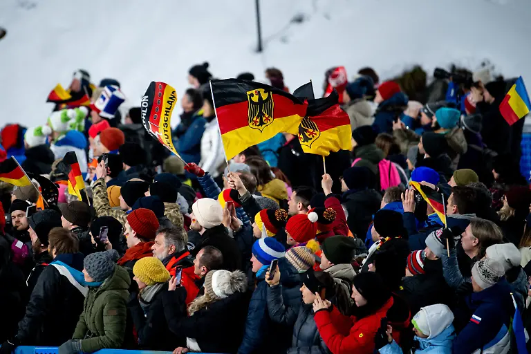 Fans-supporters-Zuschauer-spectators-mit-Fahnen-von-Deutschland-ITA-Olympische-Spiele-Milano-Cortina-2026-Olympia-Skispringen-Normalschanze-Einzel-Herren-09-02