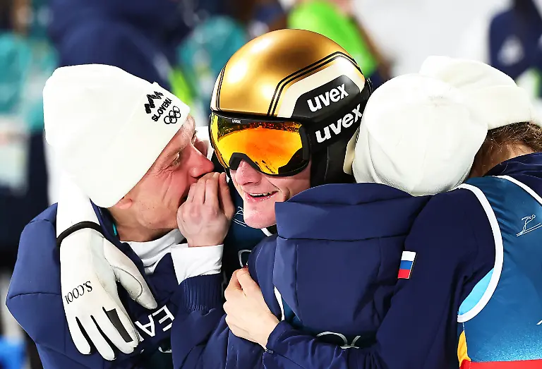 Olympia-Olympische-Winterspiele-Mailand-Cortina-2026-Ski-nordisch-Skispringen-Team-Mixed-Durchgang-2-Domen-Prevc-2-v-l-Slowenien-jubelt-nach-seinem-Sprung-mit-den-Teamkollegen-Anze-Lanisek-l-Nika-Prevc-2-v-r-und-Nika-Vodan-alle-Slowenien-ueber-den-Sieg