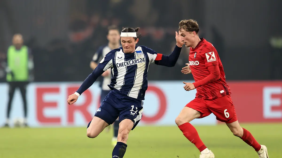 Fussball-Maenner-DFB-Pokal-Hertha-BSC-SC-Freiburg-Viertelfinale-Olympiastadion-Fabian-Reese-l-Hertha-BSC-und-Patrick-Osterhage-SC-Freiburg-kaempfen-um-den-Ball