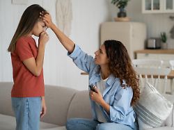 Worried Hispanic Woman Mother Touching Sick Child Forehead Checking Her Daughter Body Temperature Pre Teen Girl Coughing Feeling Unwell Having Cold Or Flu Symptoms