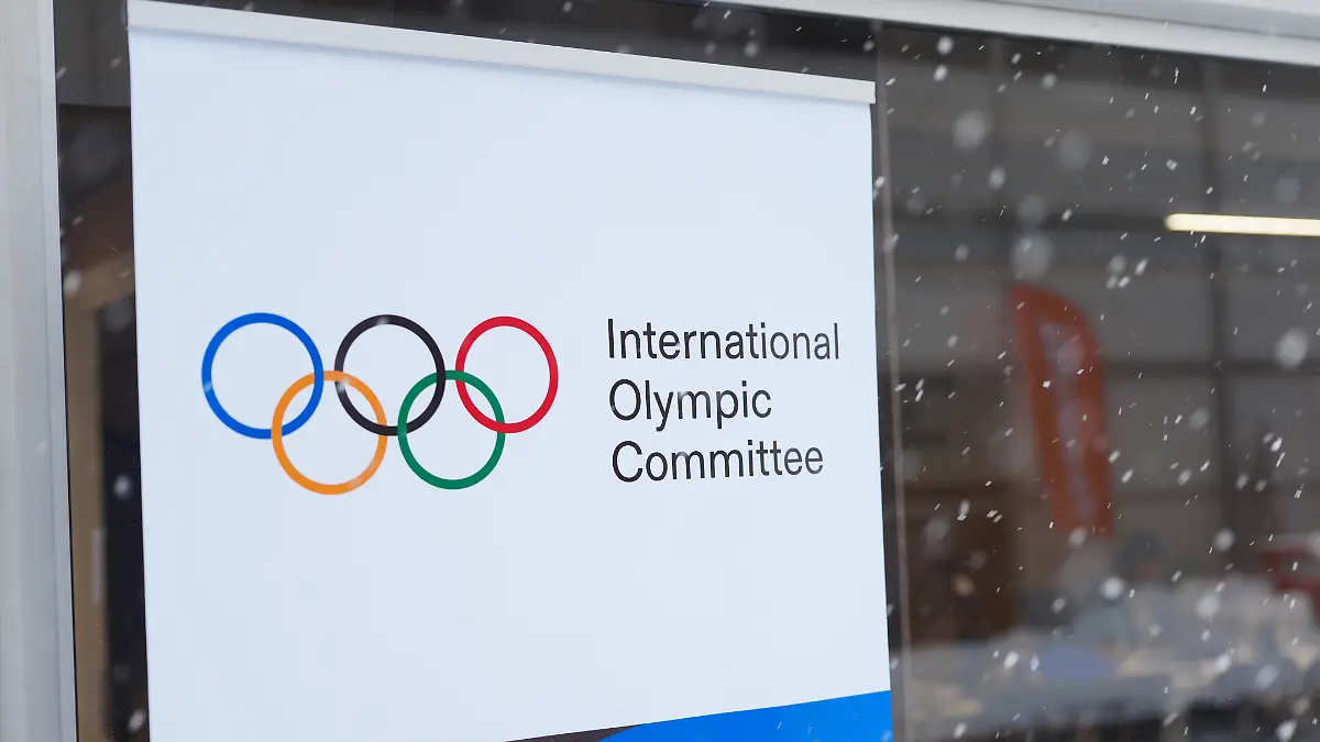 Olympia-Olympische-Winterspiele-Mailand-Cortina-2026-Ein-Hinweisschild-mit-der-Aufschrift-International-Olympic-Commitee-IOC-steht-im-olympischen-Dorf-in-Cortina