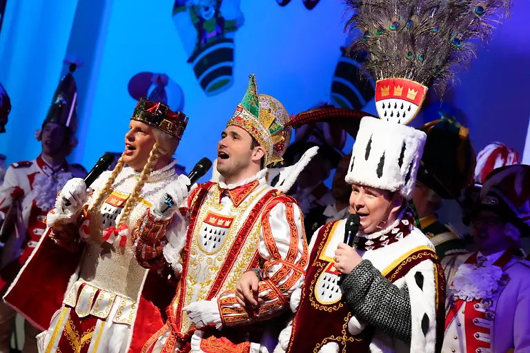 Das-Koelner-Dreigestin-um-Prinz-Niklas-I-Bauer-Clemens-und-Jungfrau-Aenne-auf-der-Buehne-bei-der-traditionellen-Maedchen-Sitzung-mit-Insassinnen-und-Haeftlingen-in-der-Justizvollzugsanstalt-JVA-Koeln-Ossendorf-Koeln-11-02