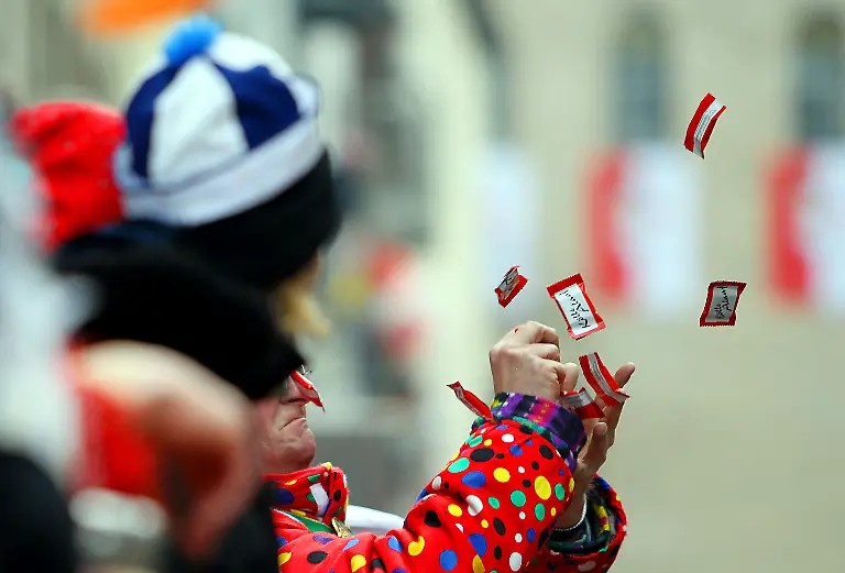 ARCHIV-Ein-Karnevalist-versucht-am-Montag-15-02-2010-in-Koeln-waehrend-des-Rosenmontagsumzuges-Kamelle-zu-fangen-Wenn-bei-den-Karnevalszuegen-die-Kamelle-fliegen-werden-viele-Jecken-zu-Strategen-Vorne-gibt-s-oft-Struessje-also-Bluemchen-dagegen-kommen-Schokoriegel-eher-in-den-hinteren-Reihen-an-Manch-einer-benutzt-Schirm-oder-Muetze-um-moeglichst-viel-zu-ergattern-Tonnenweise-Suessigkeiten-werfen-die-Karnevalisten-alljaehrlich-unters-Volk-Und-die-Ansprueche-der-Zuschauer-sind-hoch-Bei-den-grossen-Zuegen-in-den-rheinischen-Hochburgen-bueckt-sich-kaum-noch-jemand-fuer-normale-Bonbons-also-die-eigentlichen-Kamelle-obwohl-die-Zuschauer-lautstark-nach-ihnen-rufen-Foto-Oliver-Berg-dpa-lnw-zu-lnw-KORR-Kamelle-Jagd-beim-Karnevakszug-Bonbons-reichen-nicht-mehr-vom-01-03