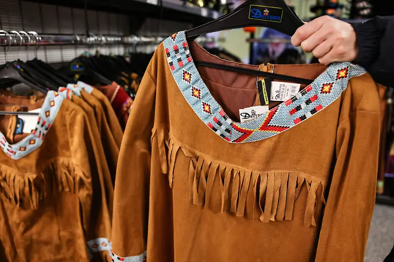 Ein-Mann-haelt-ein-Kostuem-zur-Verkleidung-als-Indianer-in-der-Hand