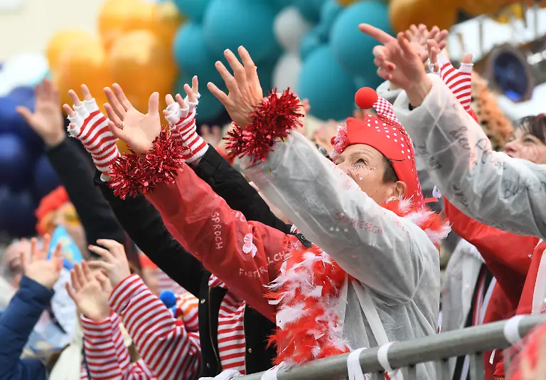 04-03-2019-Nordrhein-Westfalen-Koeln-Karnevalisten-strecken-die-Haende-in-die-Hoehe-um-Kamelle-zu-fangen-und-feiern-beim-Rosenmontagszug-Mit-den-Rosenmontagszuegen-erreicht-der-rheinische-Strassenkarneval-seinen-Hoehepunkt