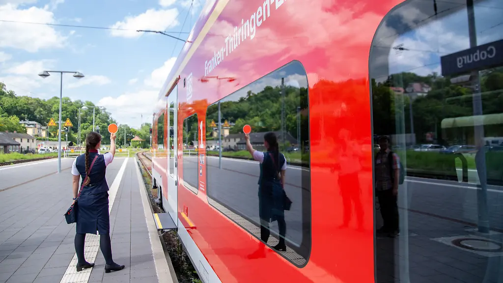 Eine-Zugbegleiterin-gibt-auf-dem-Bahnsteig-das-Signal-fuer-die-Abfahrt-des-neuen-Franken-Thueringen-Express-Am-Bahnhof-Coburg-wurden-die-neuen-sechsteiligen-Siemens-Zuege-vom-Typ-Desiro-HC-Baureihe-4462-fuer-die-Schnellfahrstrecke-Nuernberg-Erfurt-vorgestellt-Der-Franken-Thueringen-Express-absolvierte-anschliessend-seine-Premierenfahrt