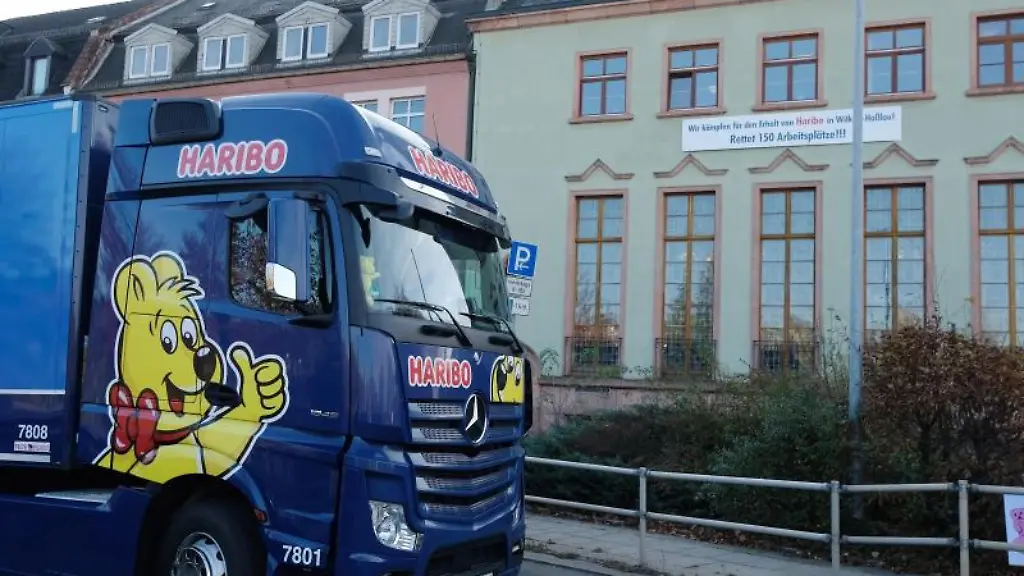 Ein-LKW-mit-Haribo-Beschriftung-faehrt-am-Rathaus-vorbei