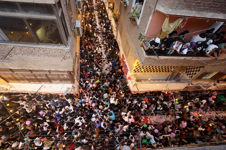 Egyptian-residents-of-Ezbet-Hamada-in-Cairo-s-Mataria-district-gather-to-eat-Iftar-the-meal-to-end-their-fast-at-sunset-during-the-holy-fasting-month-of-Ramadan-in-Cairo-Egypt-March-15