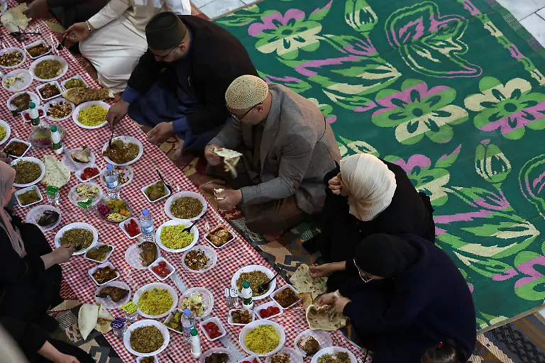Iraqi-Muslims-eat-Iftar-the-meal-to-end-their-fast-at-sunset-during-the-holy-fasting-month-of-Ramadan-at-the-shrine-of-Sheikh-Abdul-Qadir-al-Gailani-in-Baghdad-Iraq-March-13-2025