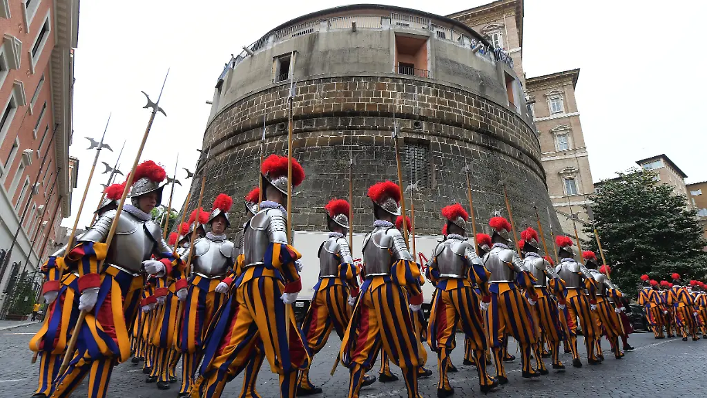 The-new-Swiss-Guards-pass-near-the-Vatican-bank-IOR-located-in-the-tower-of-Niccolo-V-at-the-Vatican-on-May-6-2015-The-Vatican-s-Swiss-Guards-swore-in-32-new-recruits-The-new-recruits-joined-their-ranks-in-an-elaborate-swearing-in-ceremony-The-ceremony-is-held-each-May-6-to-commemorate-the-147-Swiss-Guards-who-died-protecting-Pope-Clement-VII-during-the-1527-Sack-of-Rome-Then-each-new-recruit-grasped-the-corps-flag-and-raising-three-fingers-in-a-symbol-of-the-Holy-Trinity-swore-to-uphold-the-Swiss-Guard-oath-to-protect-pope-Francis-and-his-successors-The-Swiss-Guard-founded-in-1506-consists-of-100-volunteers-who-must-be-Swiss-nationals-Catholic-single-at-least-174-cm-5-feet-8-inches-tall-and-beardless-Photo-by-Eric-Vandeville-ABACAPRESS