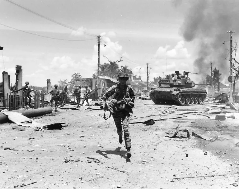 A-South-Vietnamese-marine-loaded-with-bandoliers-and-an-M-79-grenade-launcher-scurries-for-cover-as-a-tank-maneuvers-for-firing-position-in-western-Saigon-May-30-1968-Enemy-elements-had-moved-in-the-previous-night-and-were-firing-on-government-troops