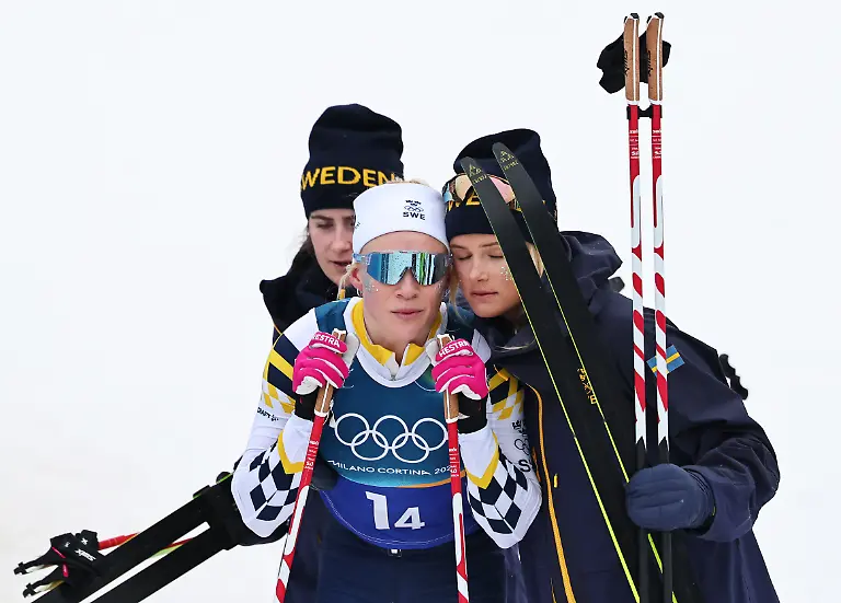 Olympia-Olympische-Winterspiele-Mailand-Cortina-2026-Ski-nordisch-Langlauf-Staffel-4-x-7-5-km-Frauen-Jonna-Sundling-M-Schweden-reagiert-im-Ziel-mit-den-Teamkolleginnen-Ebba-Andersson-l-Schweden-und-Frida-Karlsson-Schweden