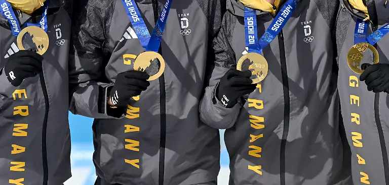 Olympia-Olympische-Winterspiele-Mailand-Cortina-2026-Biathlon-Anterselva-Biathlon-Arena-die-deutsche-Biathlon-Staffel-der-Olympichen-Spiele-von-2014-in-Sotschi-mit-Simon-Schempp-l-r-Arnd-Peiffer-Daniel-Boehm-und-Erik-Lesser-freut-sich-nachtraeglich-ueber-die-Goldmedaille-Gold-wurde-Deutschland-nachtraeglich-zugesprochen-da-Russland-in-einem-jahrelangen-Verfahren-wegen-Dopings-disqualifiziert-wurde