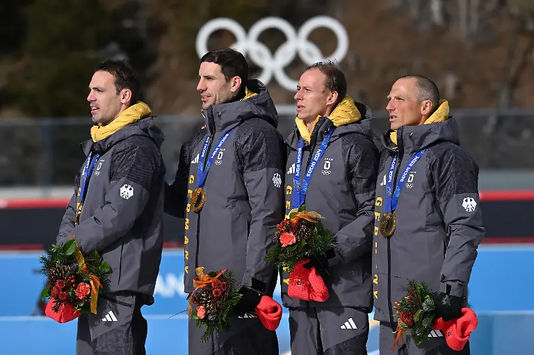 Olympia-Olympische-Winterspiele-Mailand-Cortina-2026-Biathlon-Anterselva-Biathlon-Arena-die-deutsche-Biathlon-Staffel-der-Olympichen-Spiele-von-2014-in-Sotschi-mit-Simon-Schempp-l-r-Arnd-Peiffer-Daniel-Boehm-und-Erik-Lesser-freut-sich-nachtraeglich-ueber-die-Goldmedaille-Gold-wurde-Deutschland-nachtraeglich-zugesprochen-da-Russland-in-einem-jahrelangen-Verfahren-wegen-Dopings-disqualifiziert-wurde