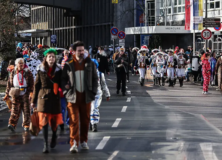 Verkleidete-Menschen-gehen-in-Richtung-des-Rosenmontagsumzugs-Der-Rosenmontagsumzug-gilt-als-Hoehepunkt-der-Mainzer-Fastnacht
