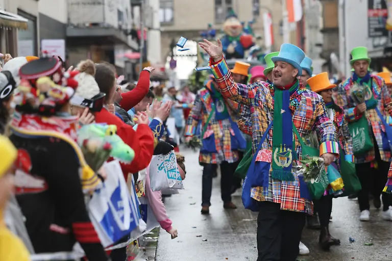 Karnevalisten-werfen-Suessigkeiten-den-Zuschauer-am-Strassenrand-zu-Der-Rosenmontag-am-Rhein-ist-der-Hoehepunkt-der-rheinischen-Karnevalssaison-mit-den-traditionellen-Umzuegen