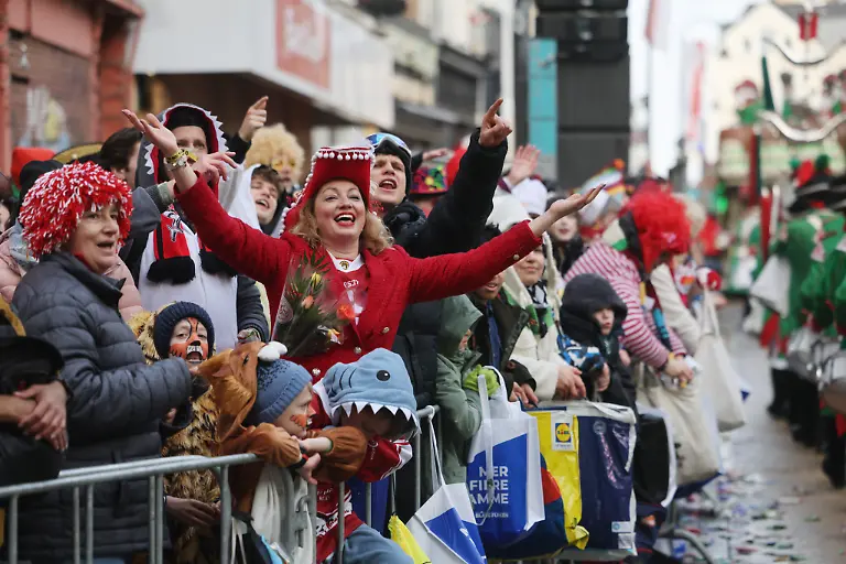 Karnevalisten-feiern-am-Strassenrand-beim-Rosenmontagszug-in-Koeln-Der-Rosenmontag-am-Rhein-ist-der-Hoehepunkt-der-rheinischen-Karnevalssaison-mit-den-traditionellen-Umzuegen
