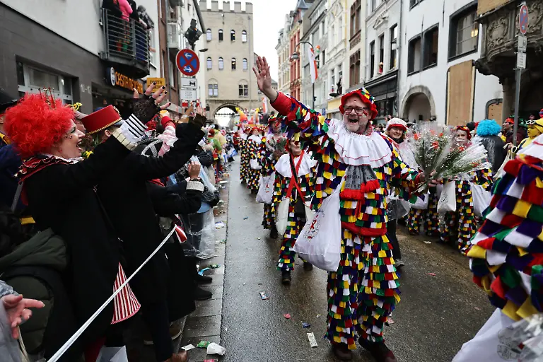 Karnevalisten-gruessen-die-Zuschauer-am-Strassenrand-Der-Rosenmontag-am-Rhein-ist-der-Hoehepunkt-der-rheinischen-Karnevalssaison-mit-den-traditionellen-Umzuegen