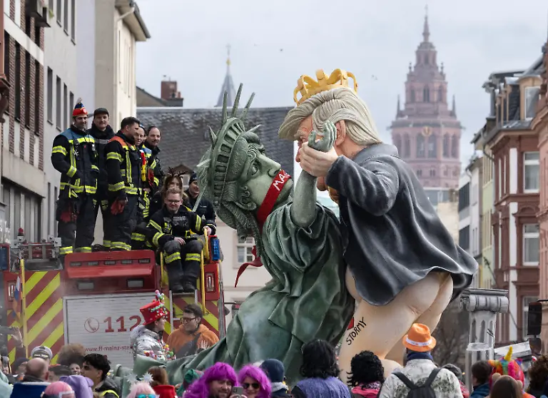 Ein-Mottowagen-zeigt-tanzende-Figuren-die-den-US-Praesidenten-Trump-r-und-die-Freiheitsstatue-darstellen-Der-naerrische-Lindwurm-umfasst-politische-Motivwagen-Schwellkoeppe-Musikzuege-Fahnentraeger-und-Garden-Die-Laenge-der-Zugstrecke-betraegt-ueber-sieben-Kilometer