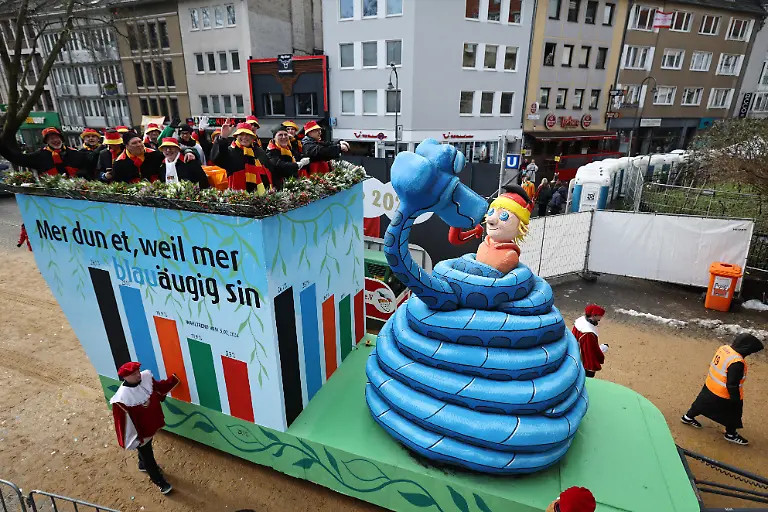 Ein-Motivwagen-mit-einer-blauen-Schlange-Kaa-die-den-deutschen-Michel-hypnotisiert-nimmt-am-Rosenmontagszug-in-Koeln-teil-Der-Rosenmontag-am-Rhein-ist-der-Hoehepunkt-der-rheinischen-Karnevalssaison-mit-den-traditionellen-Umzuegen