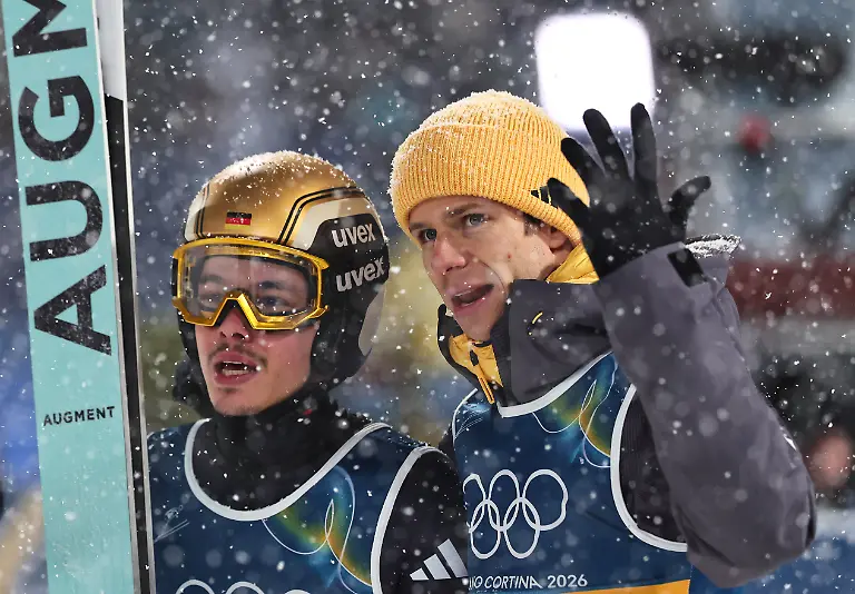 Olympia-Olympische-Winterspiele-Mailand-Cortina-2026-Ski-nordisch-Skispringen-Super-Team-Maenner-Finaldurchgang-Philipp-Raimund-l-Deutschland-reagiert-nach-seinem-Sprung-neben-Teamkollege-Andreas-Wellinger-Deutschland
