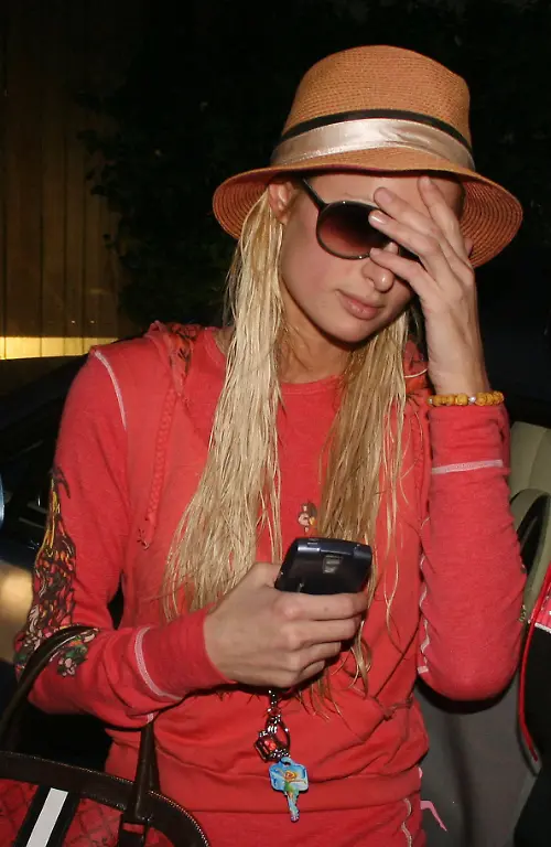 Wearing-a-straw-fedora-a-wet-haired-Paris-Hilton-goes-about-her-chores-13352-WEST-HOLLYWOOD-CALIFORNIA-Wednesday-January-10-2007-A-wet-haired-Paris-Hilton-leaving-her-house-in-a-tomato-2BFree-leisure-suit-The-25-year-old-heiress-who-is-fast-becoming-a-tourist-attraction-posed-with-fans-waiting-outside-her-home-before-heading-into-town-for-a-spray-tan-and-a-business-meeting-Paris-is-carrying-a-Signature-Montego-bowler-bag-from-Gwen-Stefani-s-label-L-A-M-B-Photograph-Ashley-Lopez-Pacificcoastnews-com-FEE-MUST-BE-AGREED-PRIOR-TO-USAGE-UK-44-131-225-3333-3322-USA-1-310-261-9676-Credit-Ashley-Lopez-Pacificcoastnews-com-Avalon-USA-PUBLICATIONxNOTxINxUKxFRAxUSA-Copyright-xAshleyxLopez-xPacificcoastnews