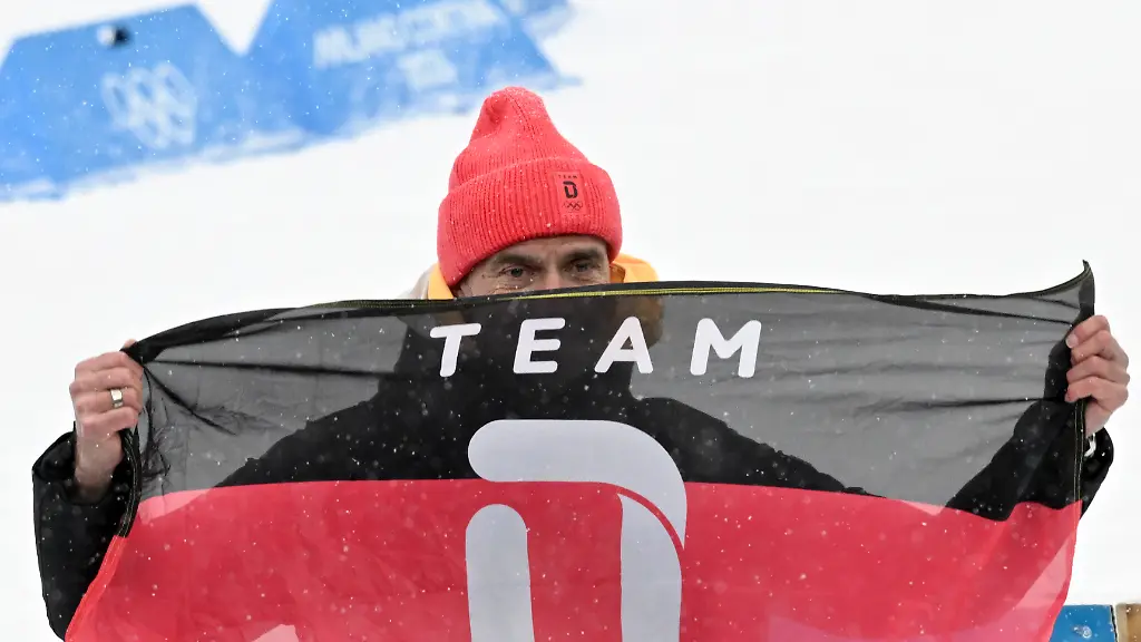 Olympia-Olympische-Winterspiele-Mailand-Cortina-2026-Biathlon-Maenner-Staffel-4-x-7-5-Kilometer-in-der-Anterselva-Biathlon-Arena-der-ehemalige-Fussball-Trainer-Juergen-Klopp-haelt-die-Fahne-vom-Team-Deutschland