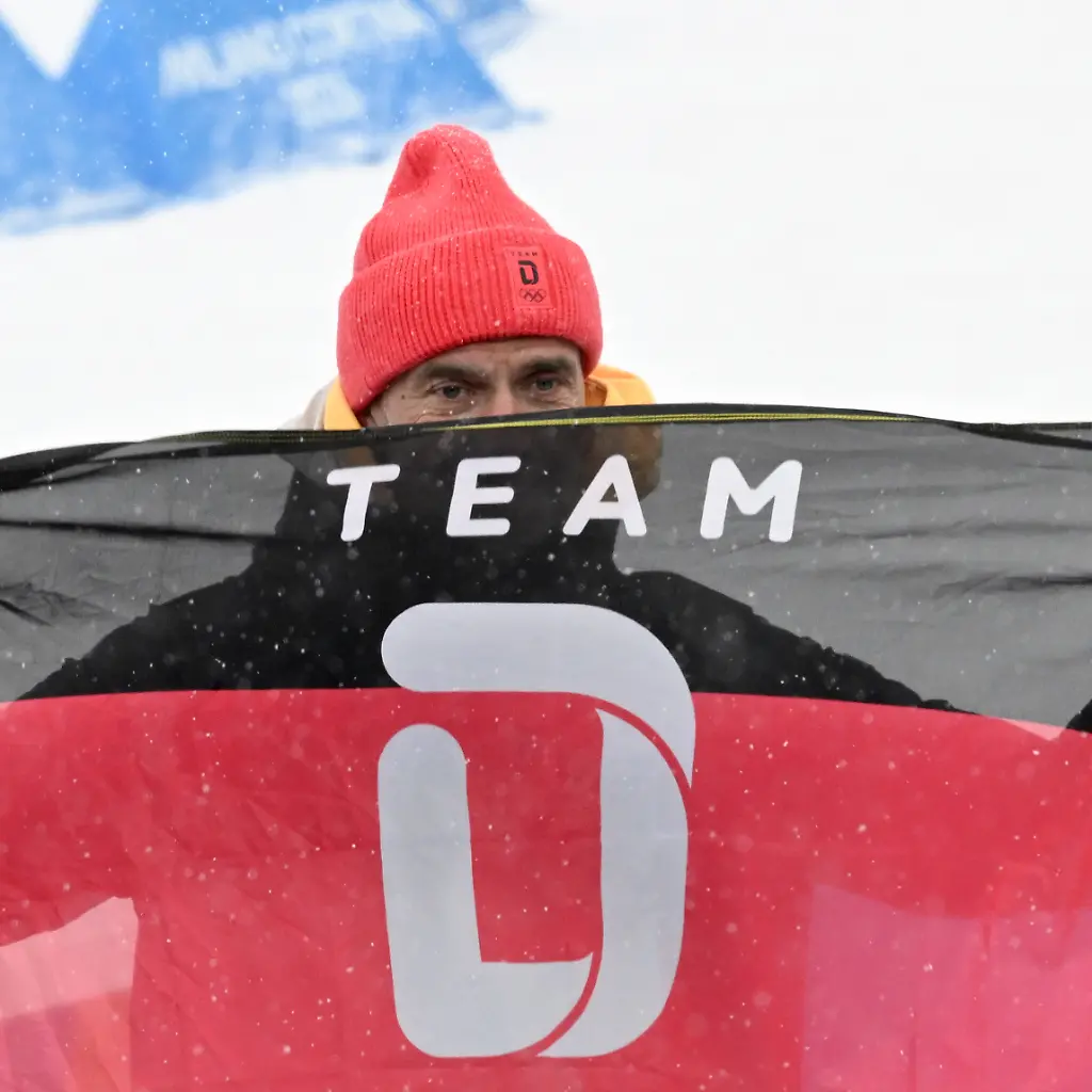 Olympia-Olympische-Winterspiele-Mailand-Cortina-2026-Biathlon-Maenner-Staffel-4-x-7-5-Kilometer-in-der-Anterselva-Biathlon-Arena-der-ehemalige-Fussball-Trainer-Juergen-Klopp-haelt-die-Fahne-vom-Team-Deutschland