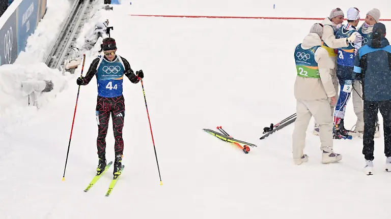 Olympia-Olympische-Winterspiele-Mailand-Cortina-2026-Biathlon-Maenner-Staffel-4-x-7-5-Kilometer-in-der-Anterselva-Biathlon-Arena-Philipp-Horn-Deutschland-l-kommt-ins-Ziel-waehrend-die-franzoesische-Staffel-ihren-Sieg-feiert